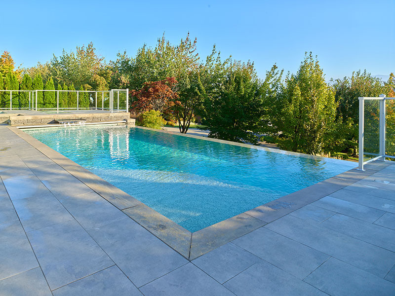 Modern infinity-edge pool showcasing high-end custom tile work and premium finishes by Rockwest Creative.