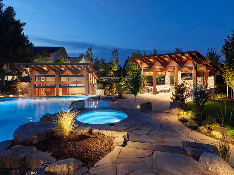 Custom timber-frame pavilion providing shaded outdoor living beside luxury pool designed by Rockwest Creative.