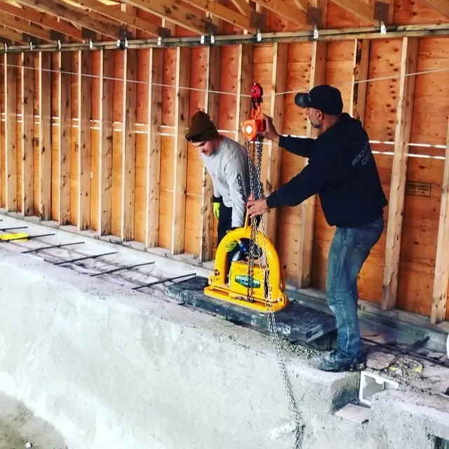 Rockwest Creative construction team carefully positioning heavy materials during a custom outdoor build